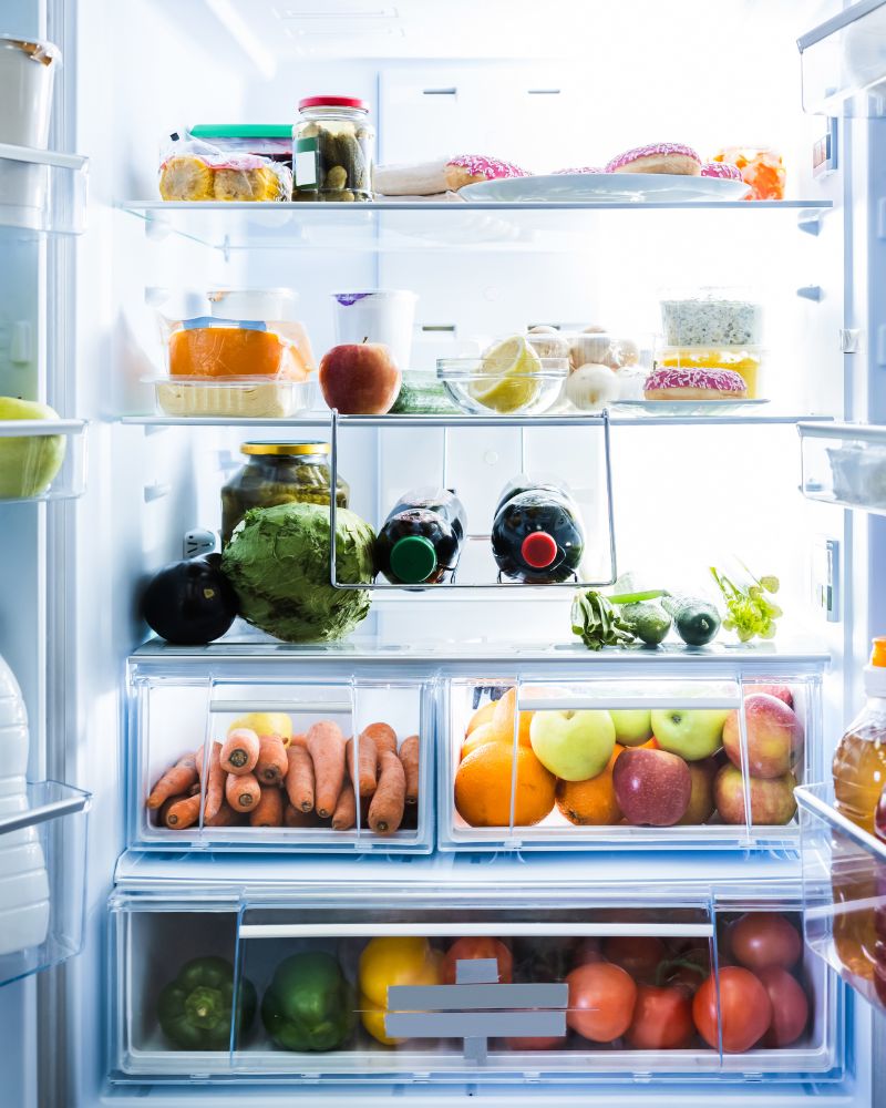 Geöffneter, gefüllter Kühlschrank mit gesunden Lebensmitteln