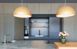 Moderne Küchenzeile mit goldenen Lampen