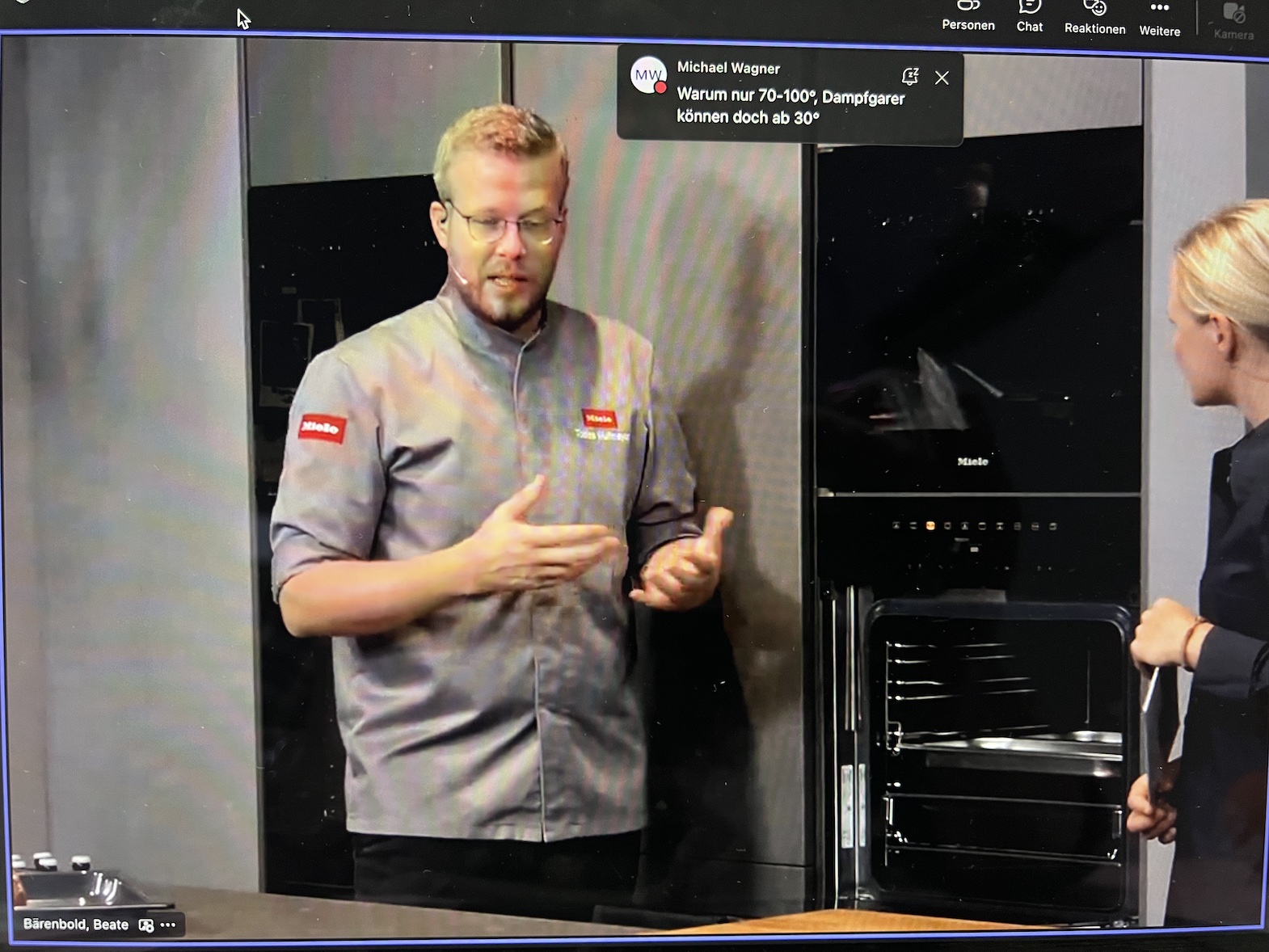 Video zur Produktschulung: Ein Mann in einem Kochhemd steht vor einem Backofen und erklärt dessen Funktion