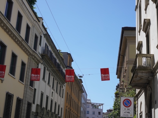 Rote Wimpel über einer Straße mit dem Schriftzug Brera